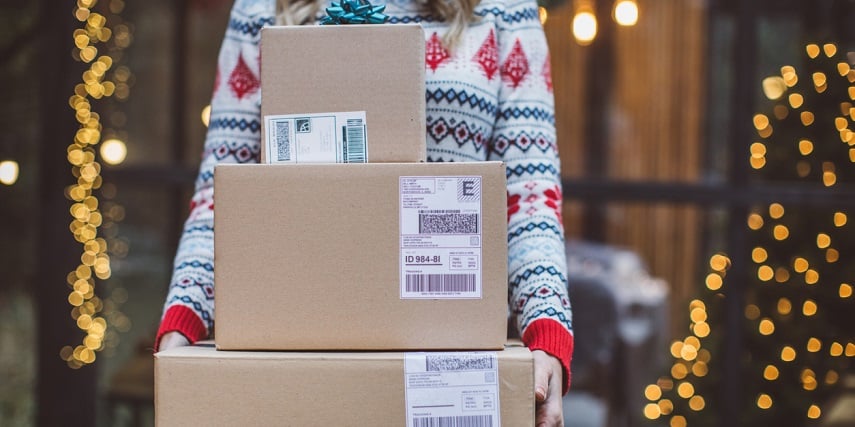 Customer carrying a stack of delivered packages