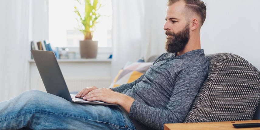 Man using a visual configurator while sitting on his sofa