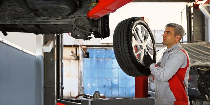 Professional installing custom tires designed through visual configuration for service and parts