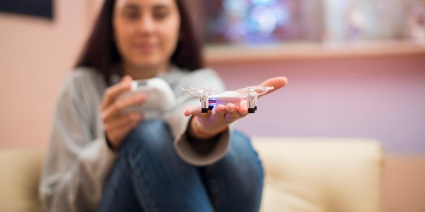 Shopper holding a small drone she designed through a toy drone configurator