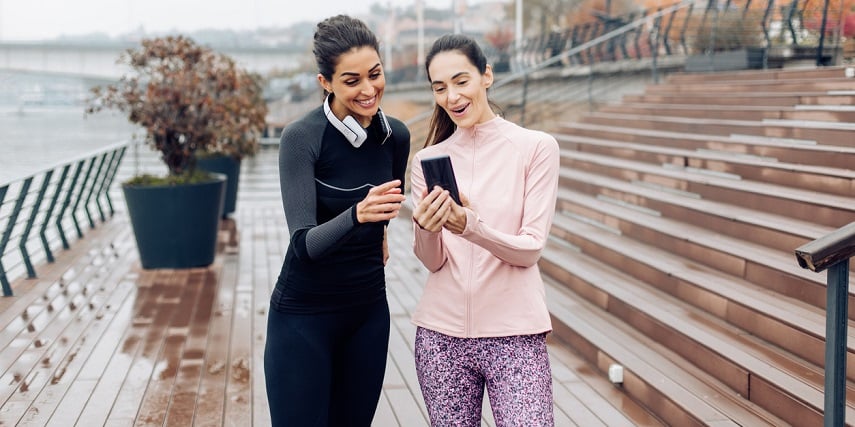 Two joggers looking at a shoe configurator as they take a break