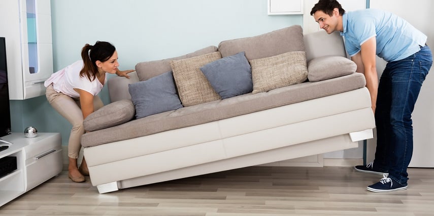 Two people moving a new couch they had ordered through a couch configurator