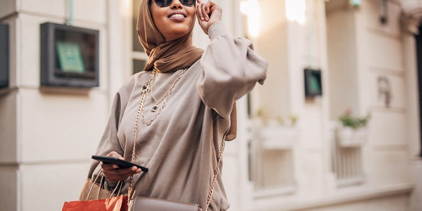 Woman holding a purse she created through a BigCommerce product configurator