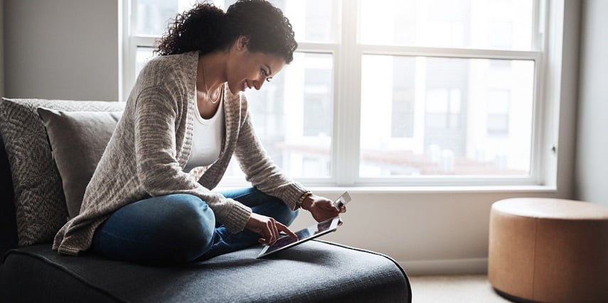 Woman shopping online at home and smiling