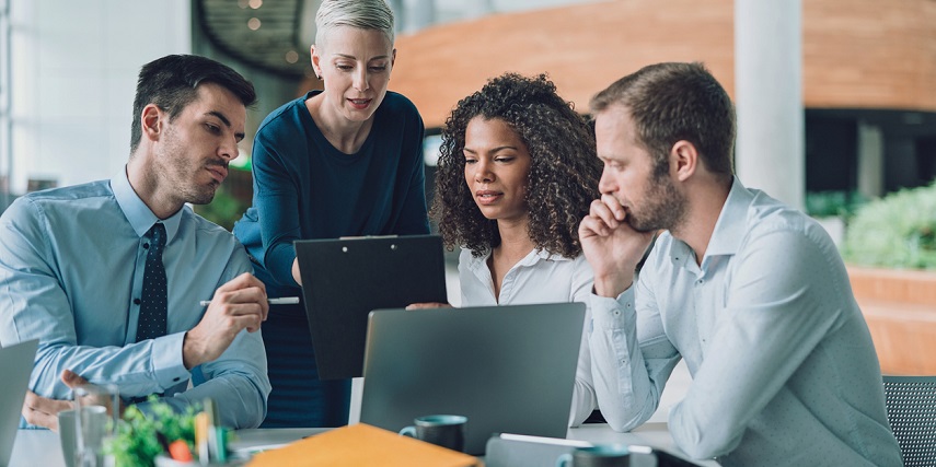 Group of business professionals collaborating around a computer screen