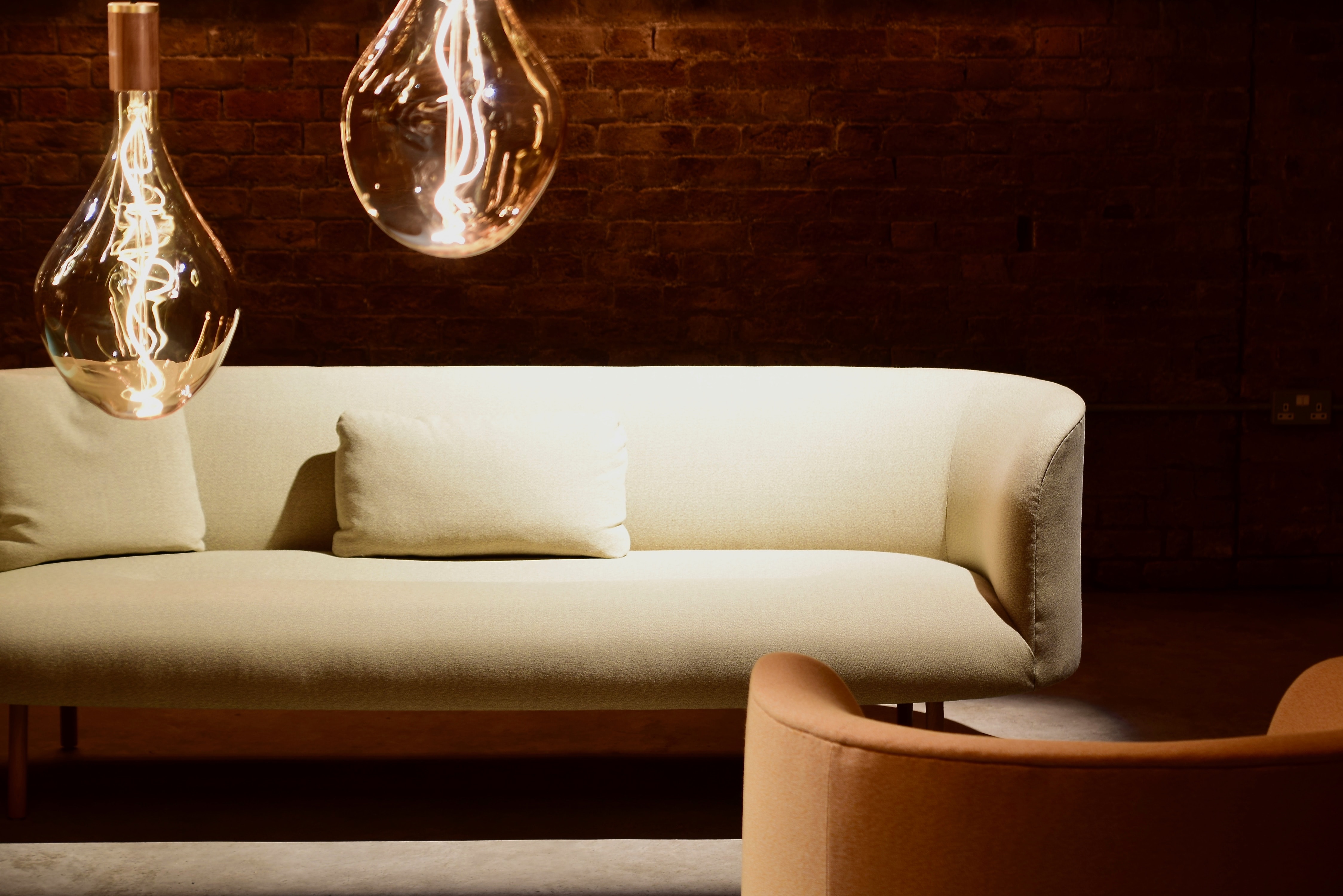 2 light bulbs with sofa in background.